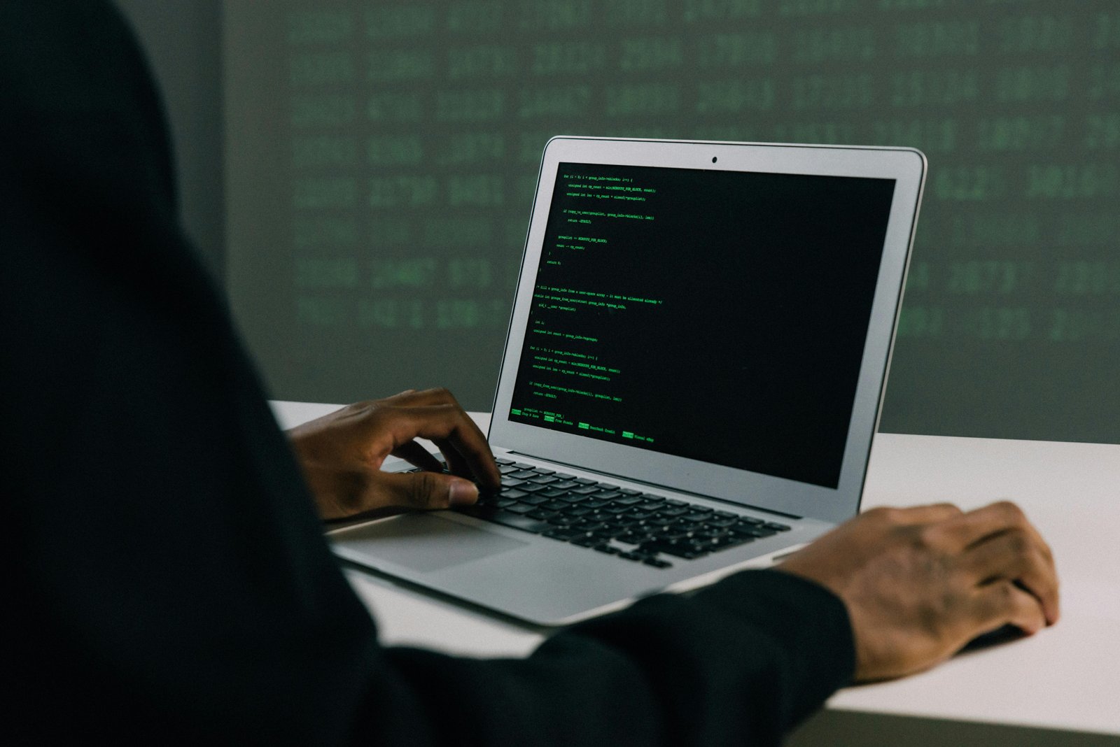 Home A focused adult working on a laptop demonstrates modern cybersecurity and coding skills indoors.